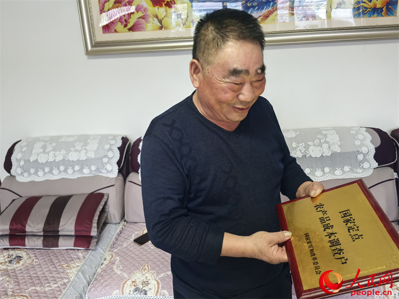 李強向記者展示他獲得的“國家定點農(nóng)產(chǎn)品成本調(diào)查戶”牌匾。人民網(wǎng)記者 陳新輝攝