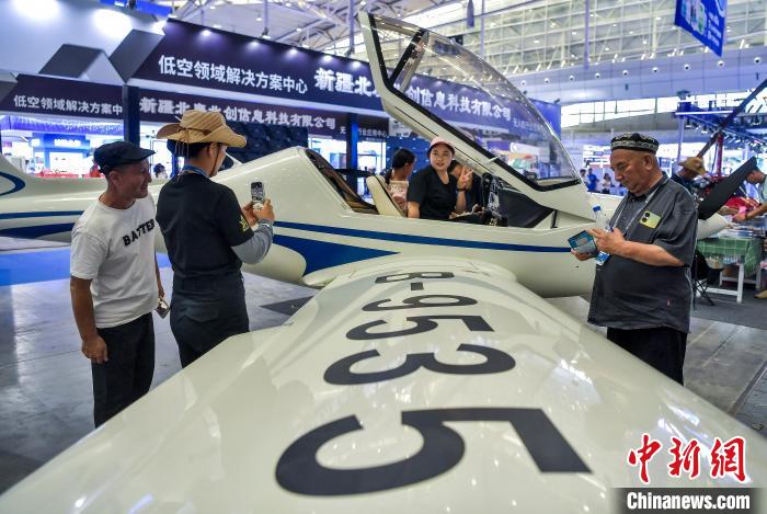 6月27日，新疆烏魯木齊市，正在新疆國際會展中心舉行的2025（中國）亞歐商品貿(mào)易博覽會低空經(jīng)濟產(chǎn)業(yè)展館，參觀者坐進一架小型飛機駕駛艙體驗、拍照。中新社記者 劉新 攝