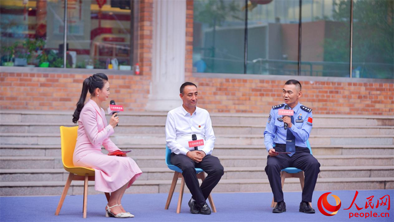 麥麥提熱伊木·買買提明（中）、何春明（右一）作交流分享。人民網(wǎng) 李欣洋攝