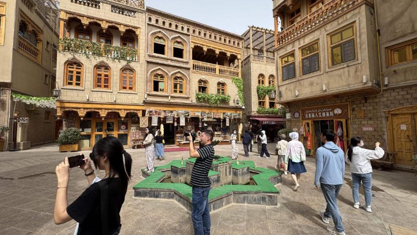 團(tuán)城特有的“阿依旺”式建筑吸引游客駐足。人民網(wǎng)記者 焦磊攝